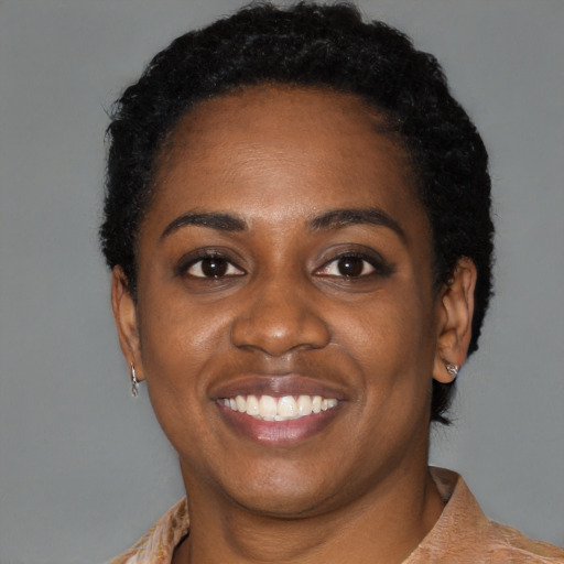 Joyful black young-adult female with short  black hair and brown eyes