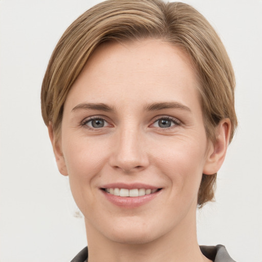 Joyful white young-adult female with short  brown hair and grey eyes