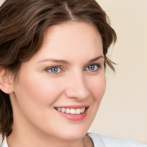 Joyful white young-adult female with medium  brown hair and blue eyes