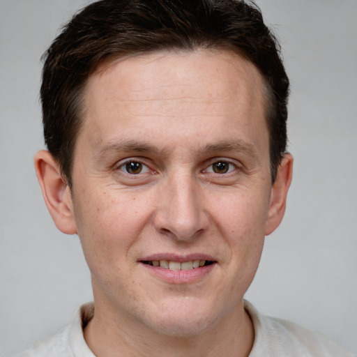 Joyful white adult male with short  brown hair and grey eyes