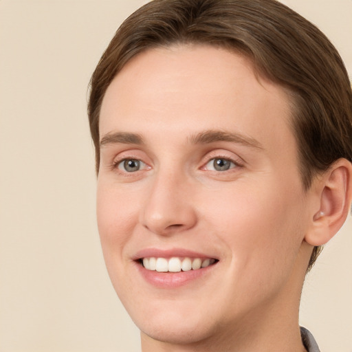 Joyful white young-adult female with short  brown hair and green eyes