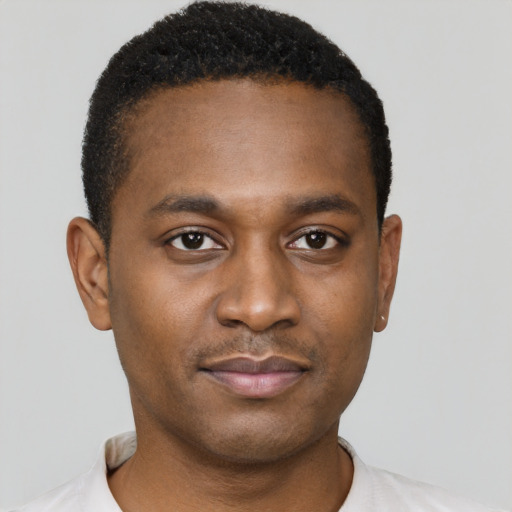 Joyful black young-adult male with short  brown hair and brown eyes