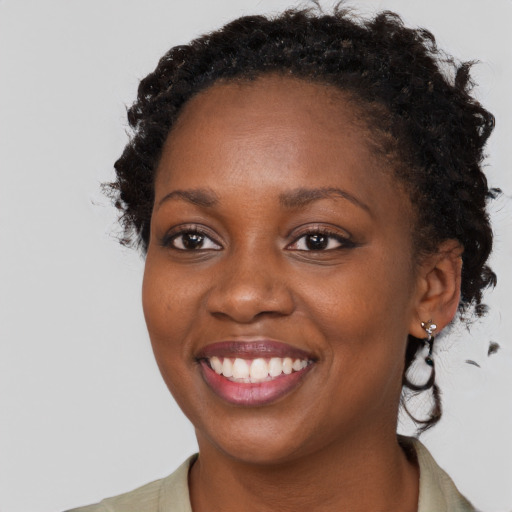 Joyful black young-adult female with medium  brown hair and brown eyes