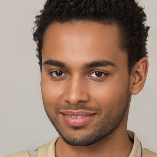 Joyful black young-adult male with short  brown hair and brown eyes