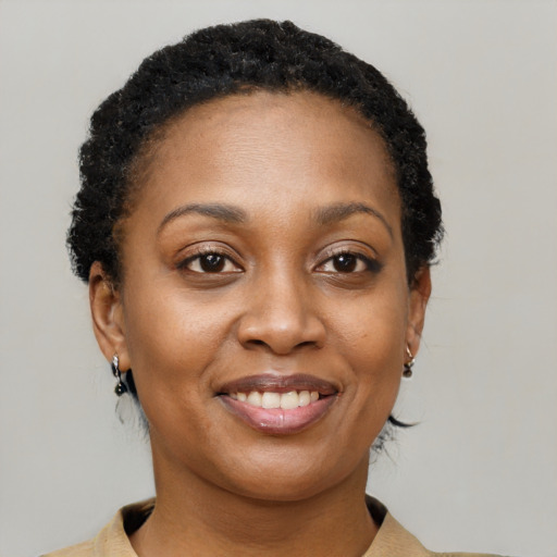 Joyful black young-adult female with short  brown hair and brown eyes
