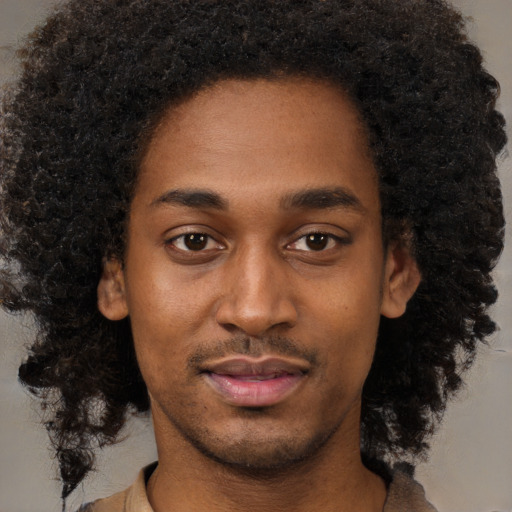 Joyful black young-adult male with short  brown hair and brown eyes