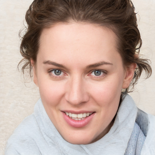 Joyful white young-adult female with medium  brown hair and blue eyes