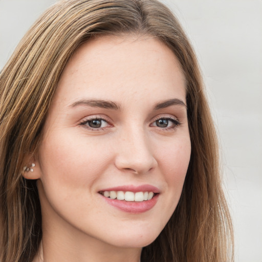 Joyful white young-adult female with long  brown hair and green eyes