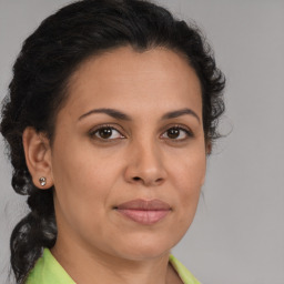 Joyful latino adult female with medium  brown hair and brown eyes