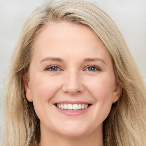 Joyful white young-adult female with long  brown hair and blue eyes