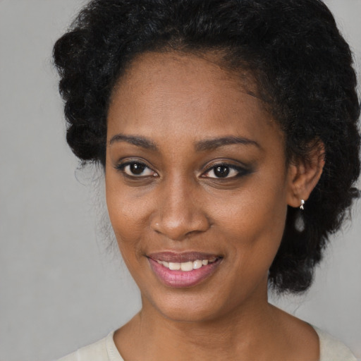 Joyful black young-adult female with medium  black hair and brown eyes
