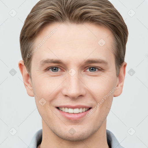 Joyful white young-adult male with short  brown hair and grey eyes