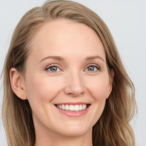 Joyful white young-adult female with long  brown hair and blue eyes