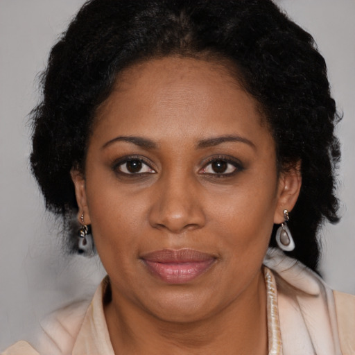 Joyful black adult female with long  brown hair and brown eyes