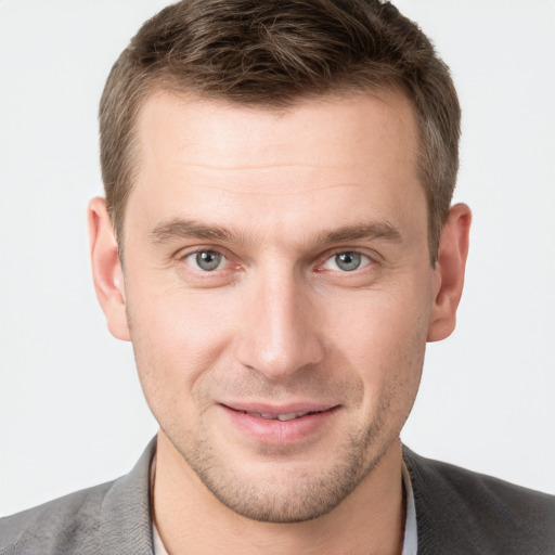 Joyful white young-adult male with short  brown hair and grey eyes