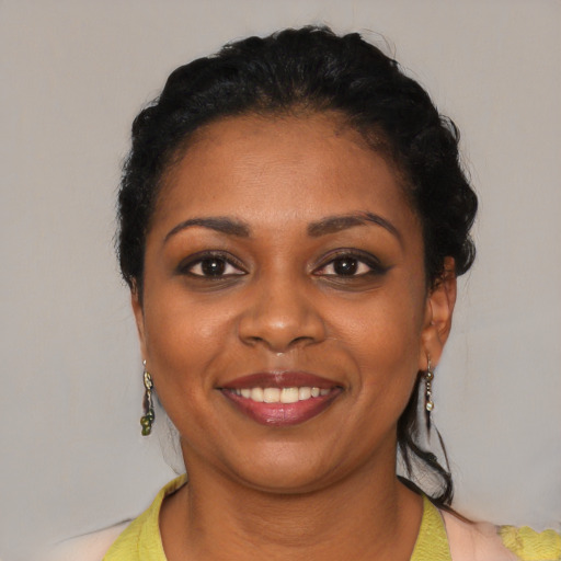 Joyful black young-adult female with short  black hair and brown eyes