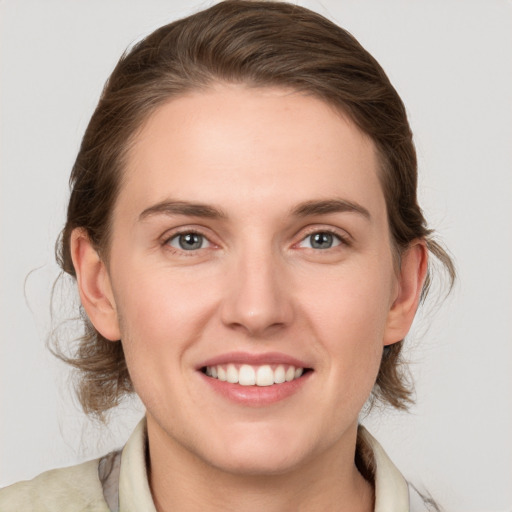 Joyful white young-adult female with medium  brown hair and grey eyes