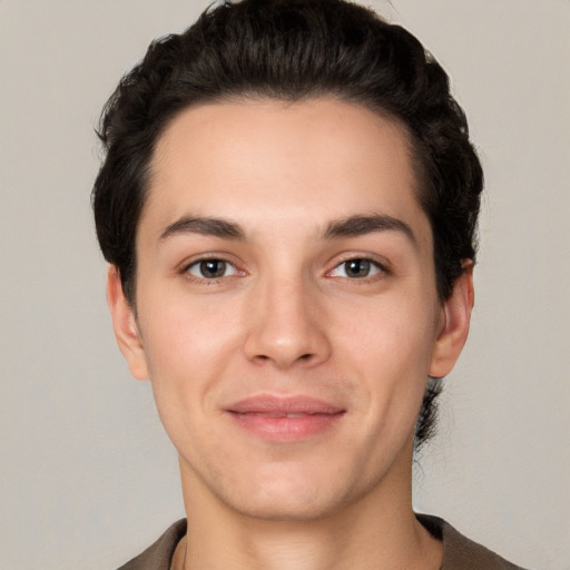 Joyful white young-adult male with short  black hair and brown eyes