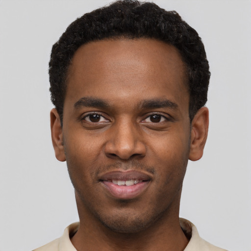 Joyful black young-adult male with short  black hair and brown eyes