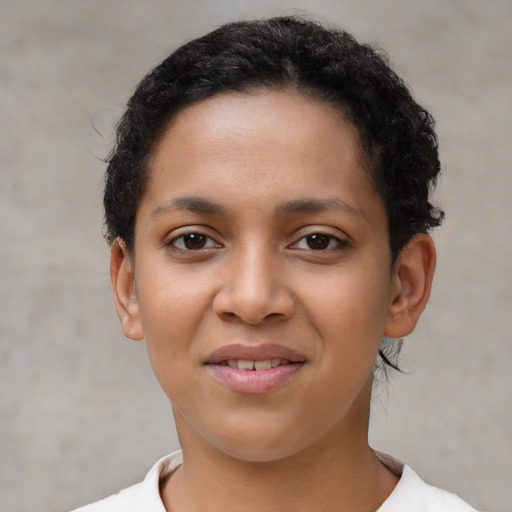 Joyful latino young-adult female with short  black hair and brown eyes