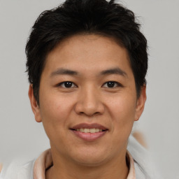 Joyful asian young-adult male with short  brown hair and brown eyes