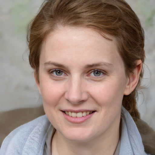 Joyful white young-adult female with medium  brown hair and blue eyes