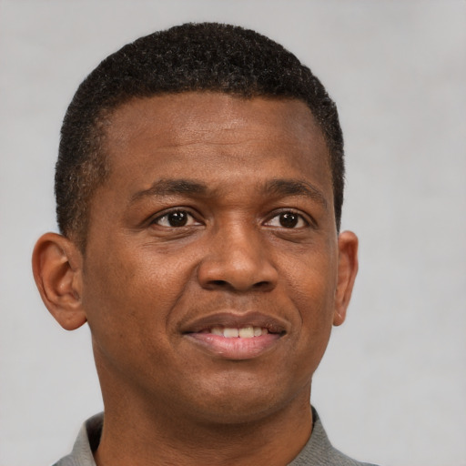Joyful black young-adult male with short  brown hair and brown eyes