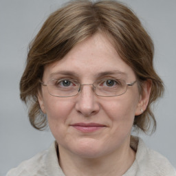 Joyful white adult female with medium  brown hair and blue eyes