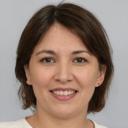 Joyful white adult female with medium  brown hair and brown eyes