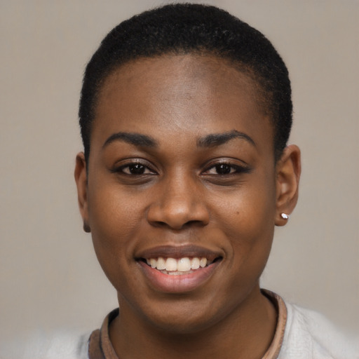 Joyful black young-adult female with short  black hair and brown eyes