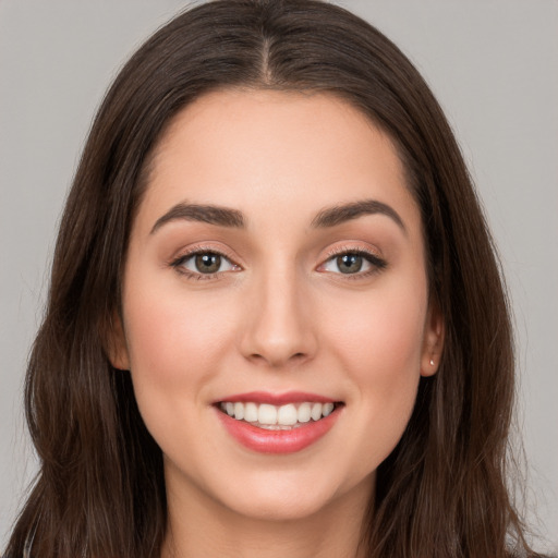 Joyful white young-adult female with long  brown hair and brown eyes