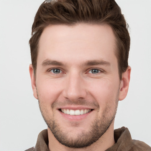 Joyful white young-adult male with short  brown hair and grey eyes