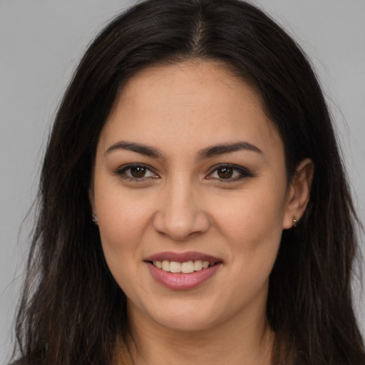 Joyful latino young-adult female with long  brown hair and brown eyes