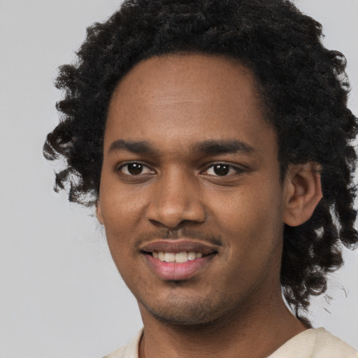 Joyful black young-adult male with short  black hair and brown eyes
