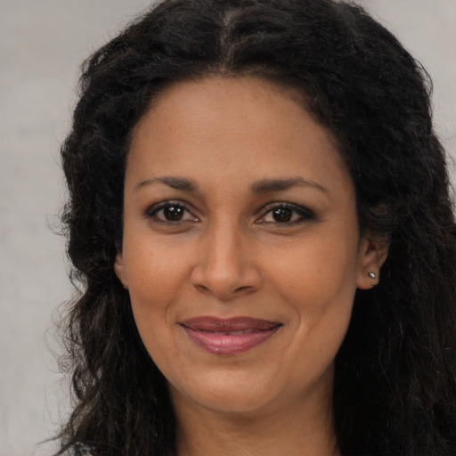 Joyful latino adult female with long  brown hair and brown eyes