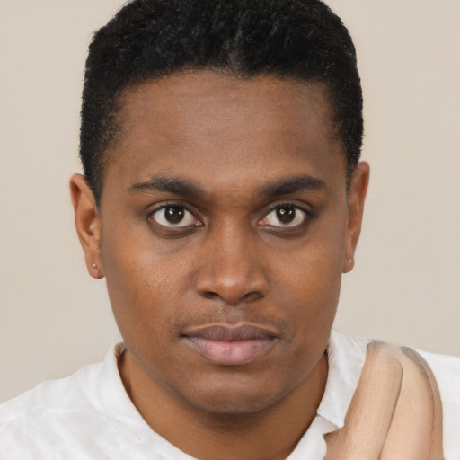 Joyful black young-adult male with short  brown hair and brown eyes