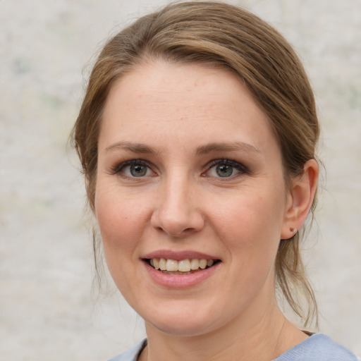 Joyful white young-adult female with medium  brown hair and blue eyes