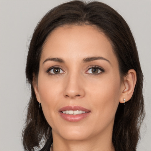 Joyful white young-adult female with long  brown hair and brown eyes