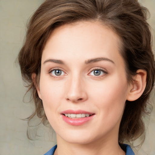 Joyful white young-adult female with medium  brown hair and blue eyes