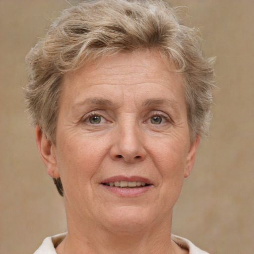 Joyful white middle-aged female with short  blond hair and brown eyes