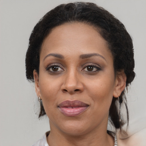 Joyful black adult female with medium  brown hair and brown eyes