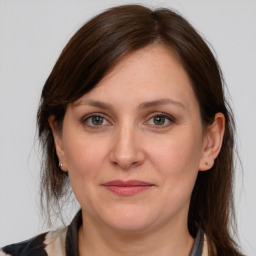 Joyful white adult female with medium  brown hair and grey eyes