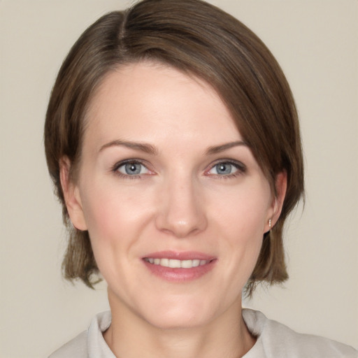 Joyful white adult female with medium  brown hair and grey eyes