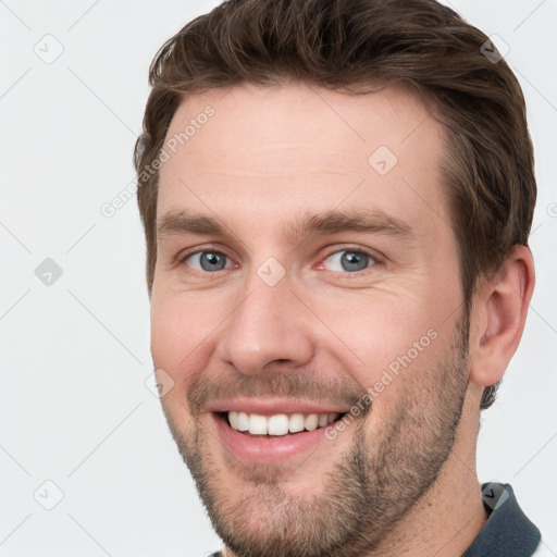 Joyful white young-adult male with short  brown hair and grey eyes