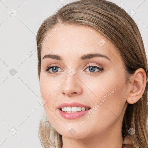 Joyful white young-adult female with long  brown hair and grey eyes