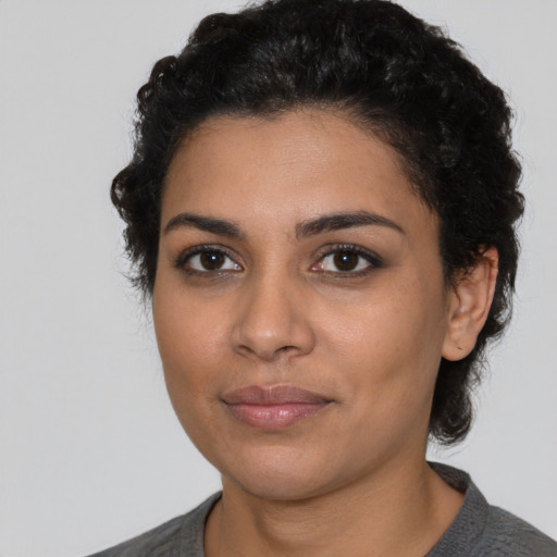 Joyful latino young-adult female with short  black hair and brown eyes