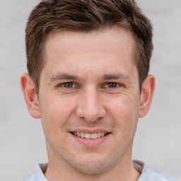 Joyful white adult male with short  brown hair and grey eyes