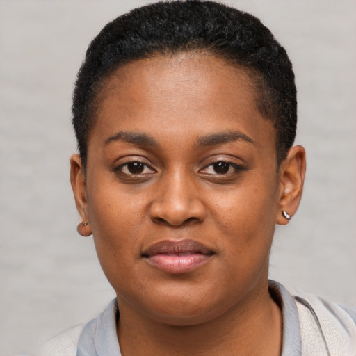 Joyful black young-adult female with short  brown hair and brown eyes