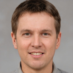 Joyful white adult male with short  brown hair and grey eyes