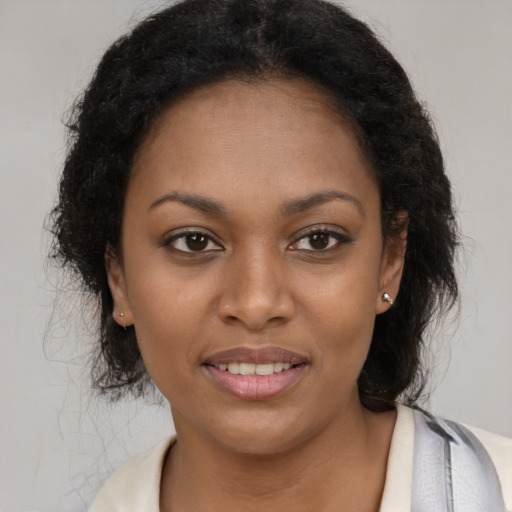 Joyful black young-adult female with long  brown hair and brown eyes